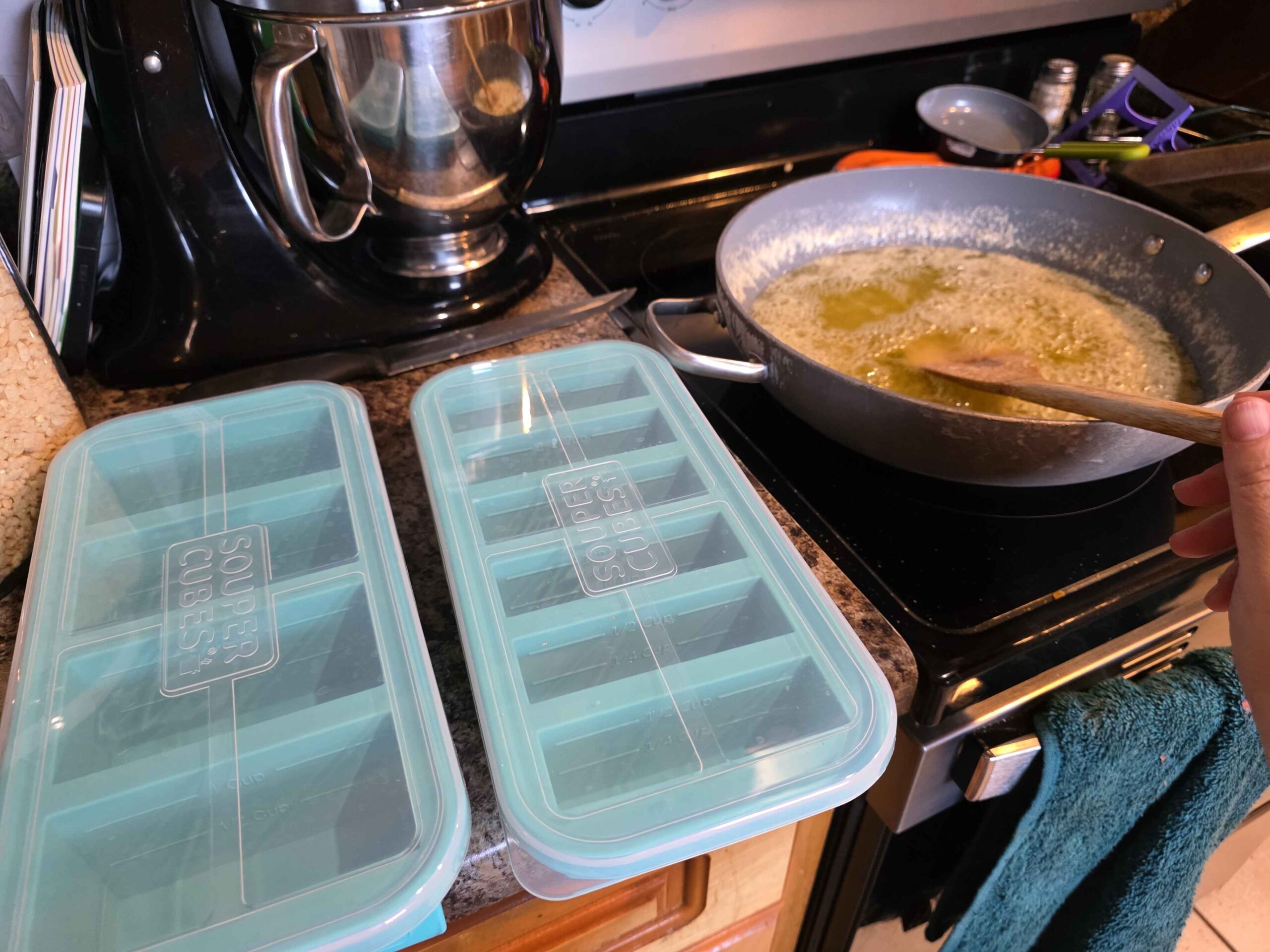 A large sauce pan on the stove full of 3 pounds of butter that is just turning brown. On the counter next to it are my 1 cup and 1/2 cup souper cubes.