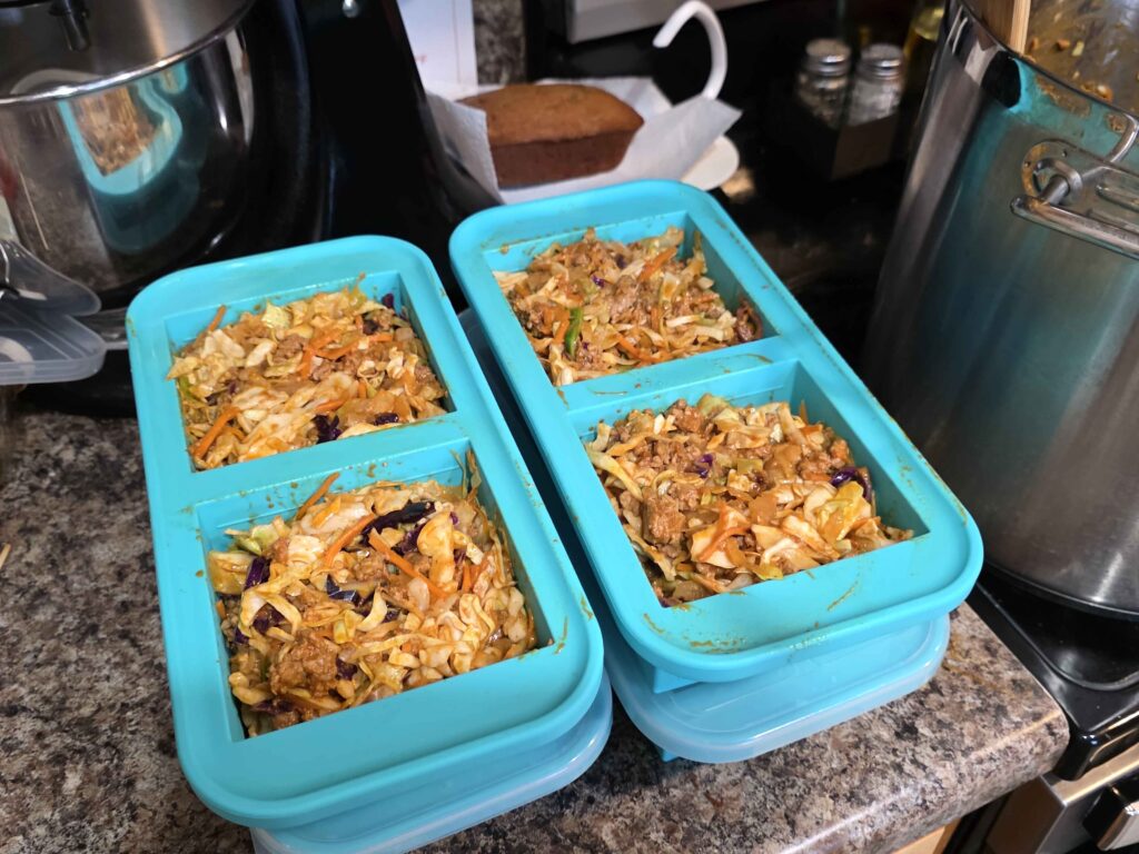 Four of our 2 cup Souper Cubes stacked up as I transfer the stir fry into them.