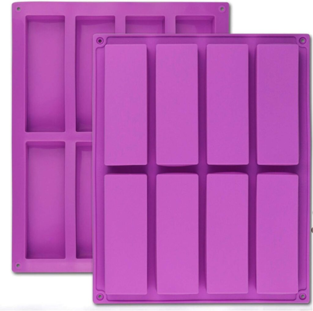 A picture of a two bright pink silicone molds with 8 granola bar sized cavities each.