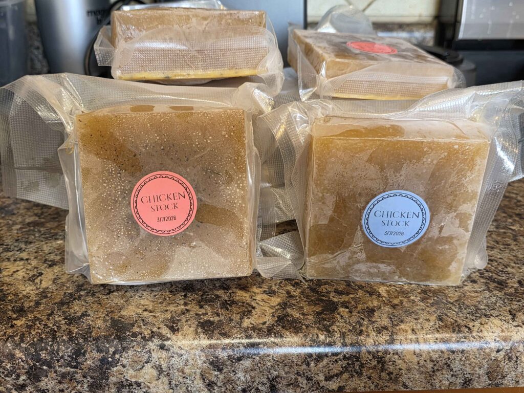 a stack of 2 cup frozen blocks of stock, all vacuum sealed and labeled